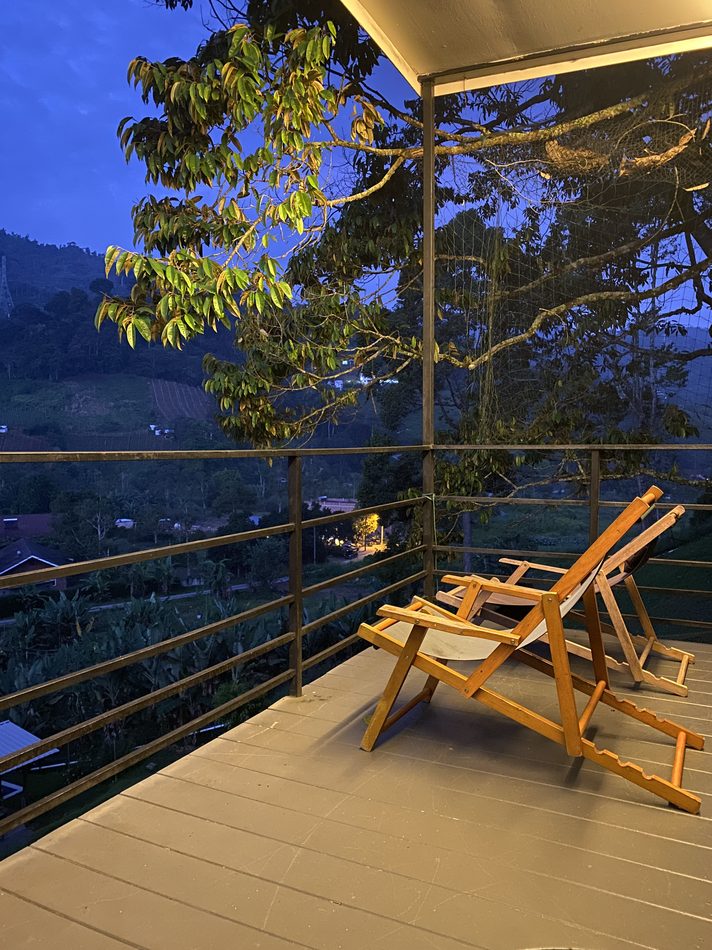 Balcony chairs looking out over the dark valley at night, distant lights below