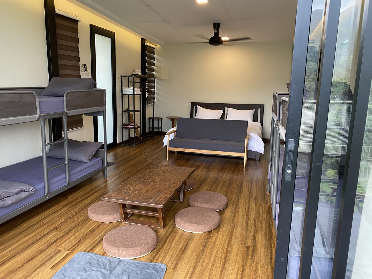 Inside Chalet 3: bunk beds either side, a low tatami table with floor cushions, and the balcony beyond