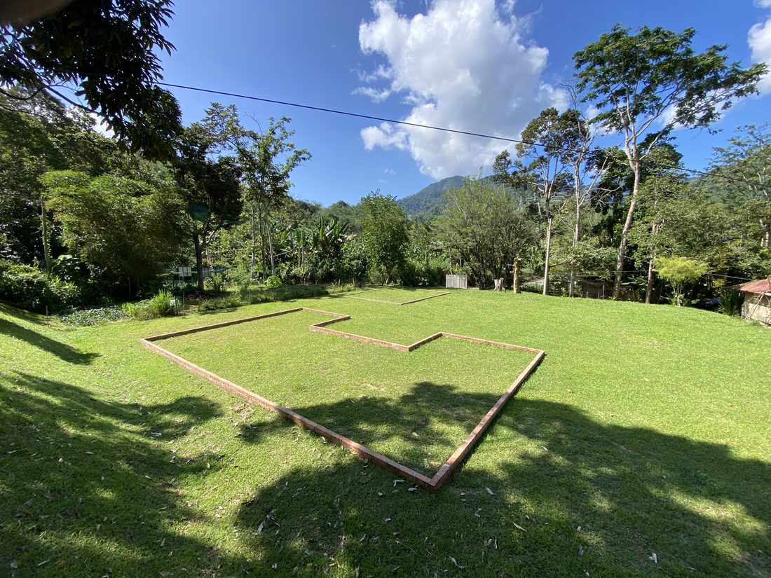 A brick foundation staked out on the lawn, marking the new glamping site
