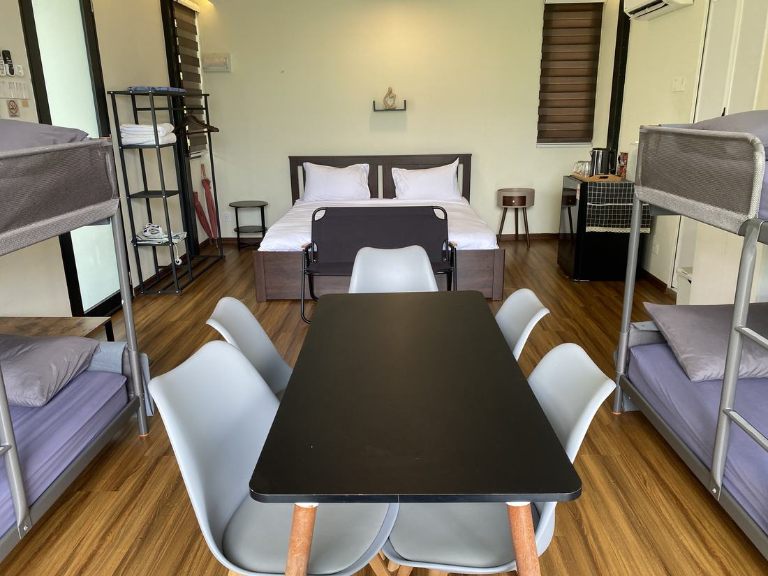 The king bed made up, with a fridge, kettle and side table alongside