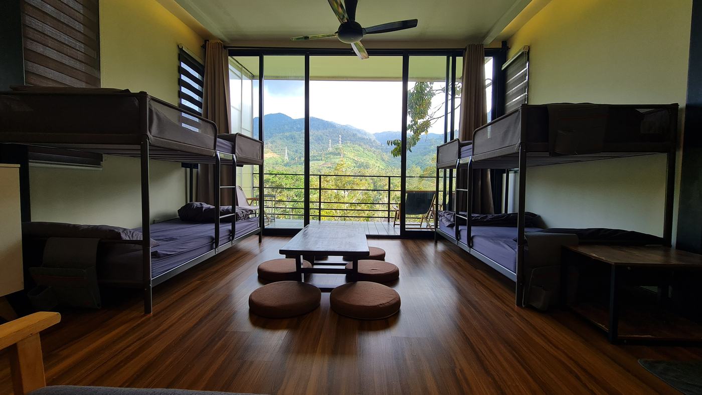 Inside the chalet: bunk beds either side, a low tatami table with floor cushions, and the balcony beyond