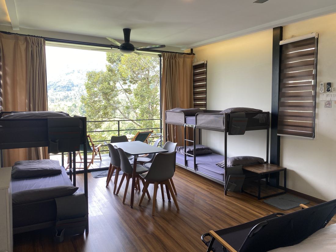Chalets 1 and 2: bunk beds either side of a standard dining table, glass doors open to the balcony